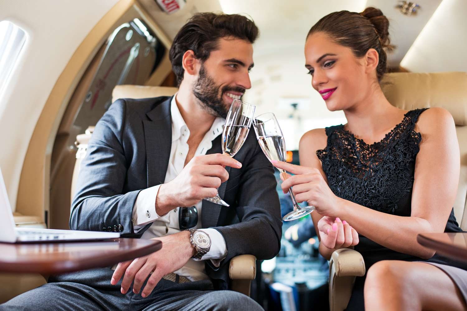 A couple toasting champagne aboard a private jet